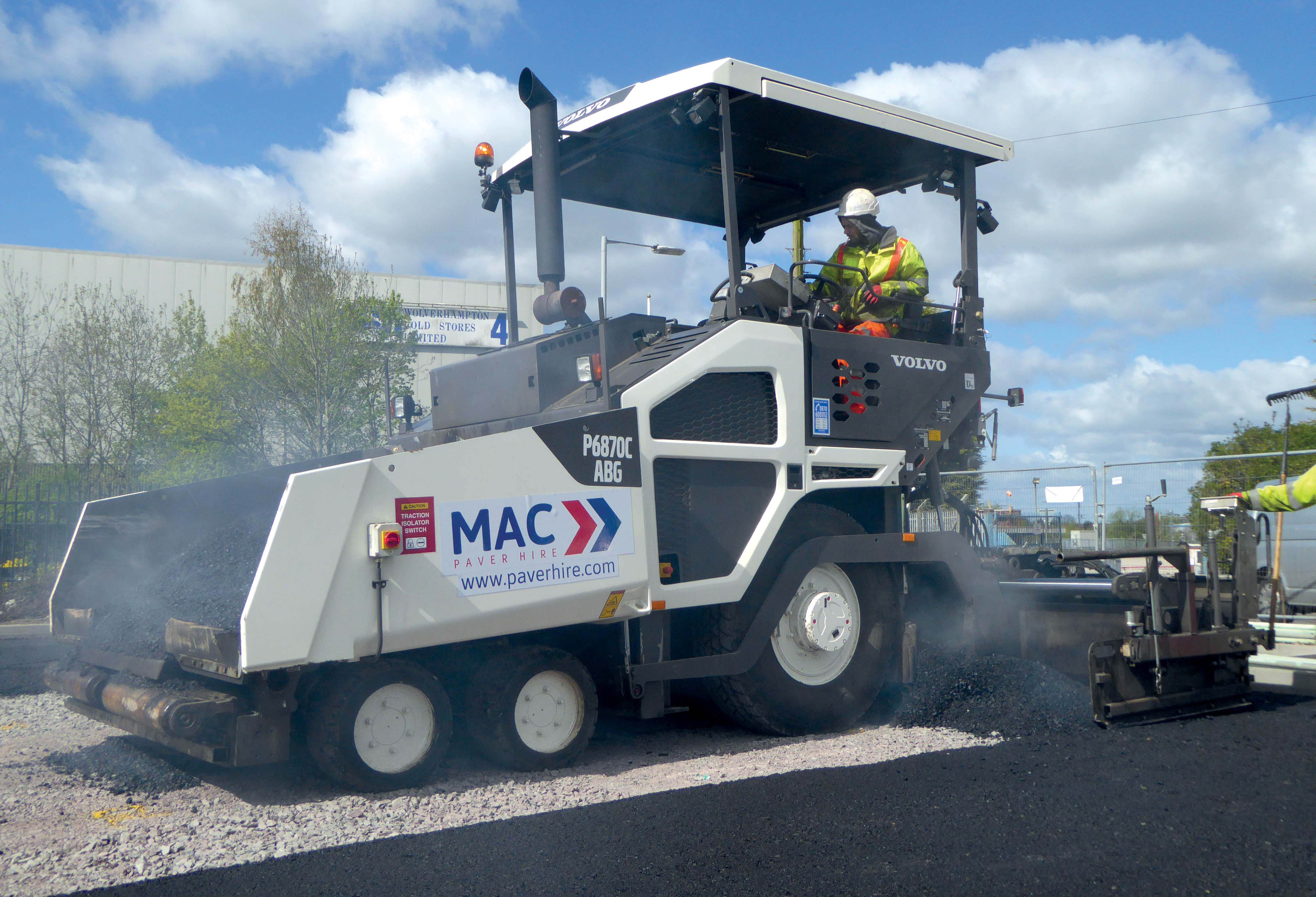A Volvo wheeled P6870C paver lays it down Volvo wheeled P6870C paver