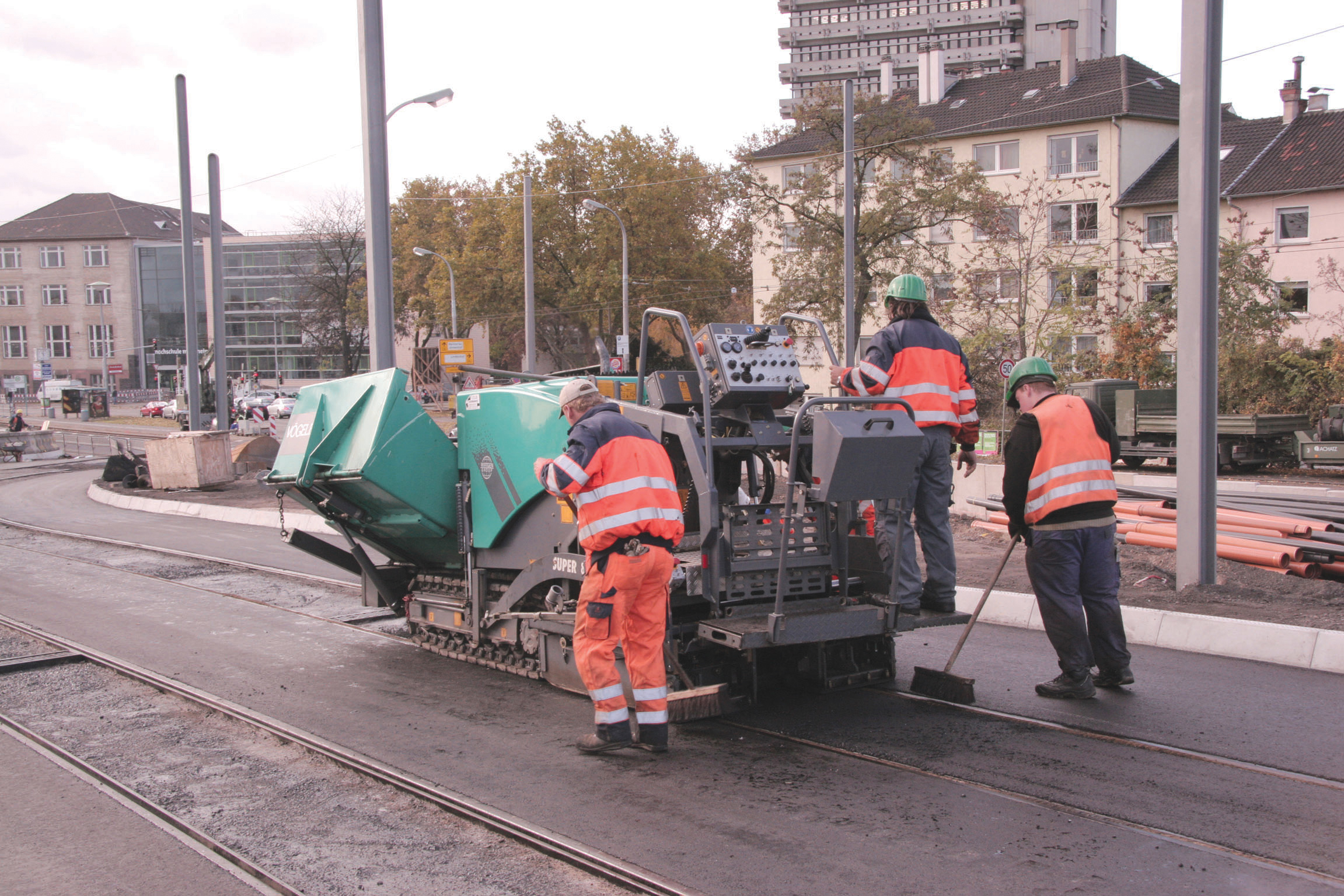 The Vögele SUPER 800 placed some 80tonnes of asphalt mix for the bridge access areas Men working with the Vogele Super 800