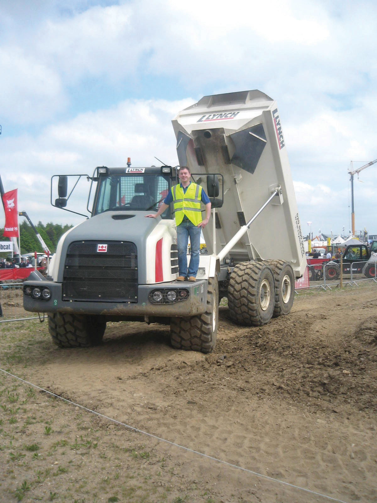 Merrill Lynch at the recent SED Exhibition with one of Lynch Plant Hire's new Terex trucks Man standing on Terex dump truck