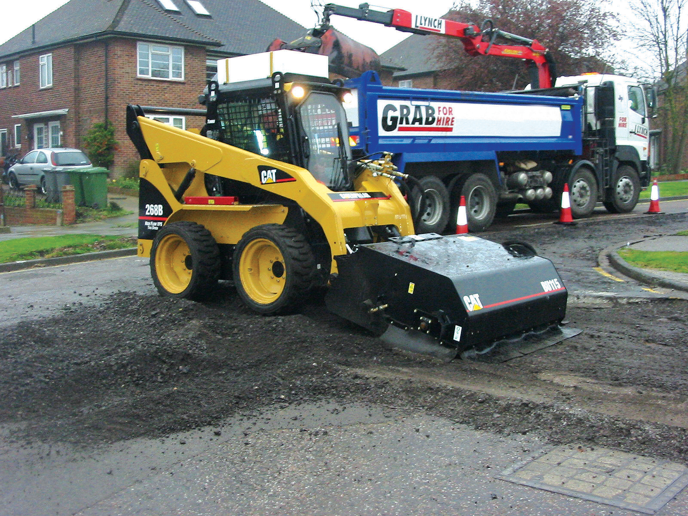 Sides skirts around this Cat planer attachment minimise dust generation CAT 268B loader