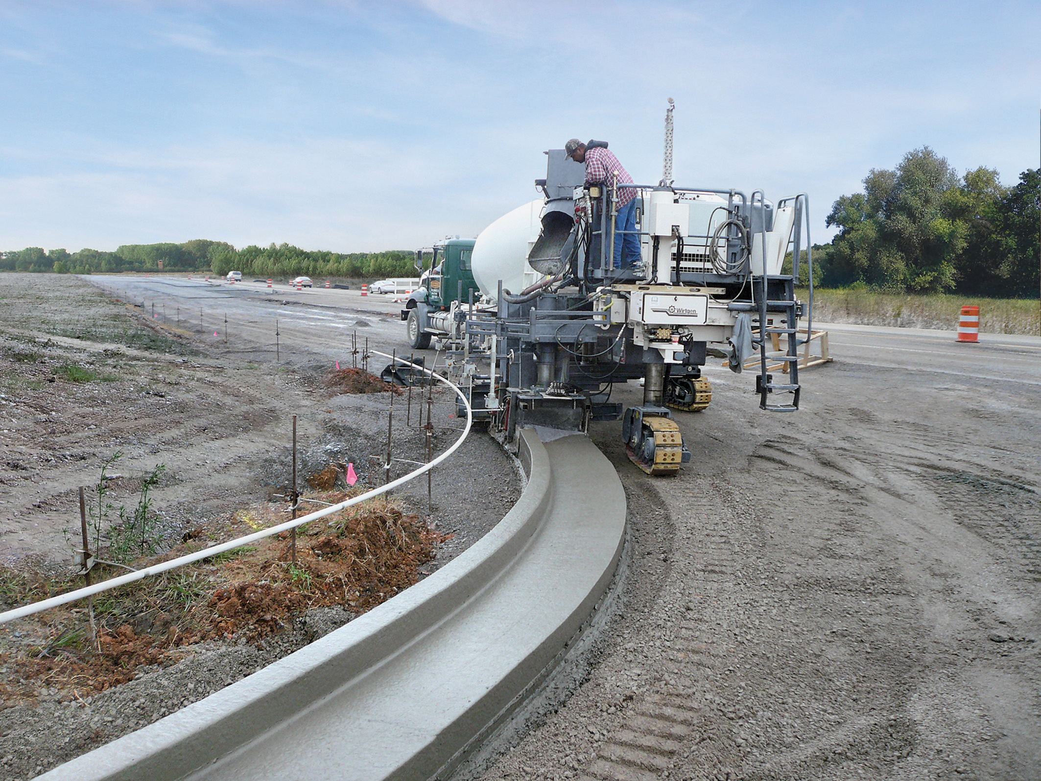 Wirtgen's new SP15 is said to offer high performance trimming capabilities, quick on-site changes for left or right side pouring and can pour tight radii with its all-track steering Wirtgen's new SP15 pouring curved barrier