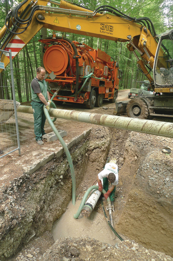 Using a powerful rig from Tracto- Technik, German contractor Beermann has managed to complete a steeply sloping utility installation under a village access road men laying pipe under rural road