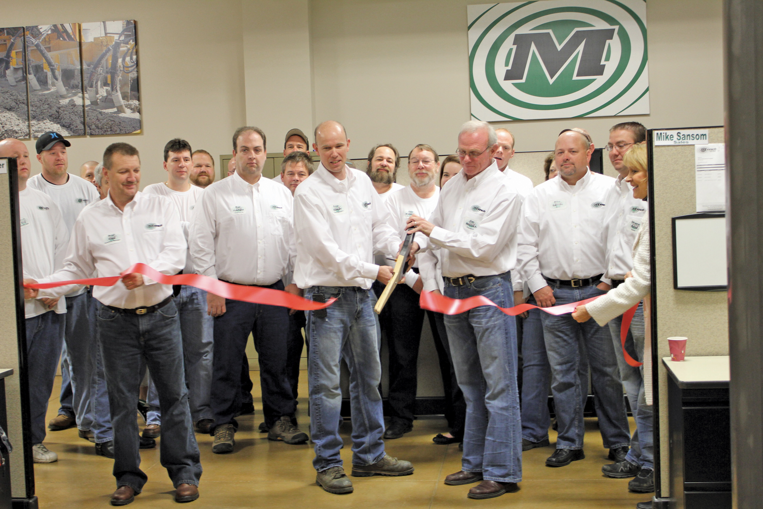 Jim Minnich (pictured on right holding scissors), owner of Minnich Manufacturing, and Troy Kingan, company plant manager, cut the ribbon to mark the official opening of MM’s Ashland County HQ during the recent Open House event Minnich Manufacturing