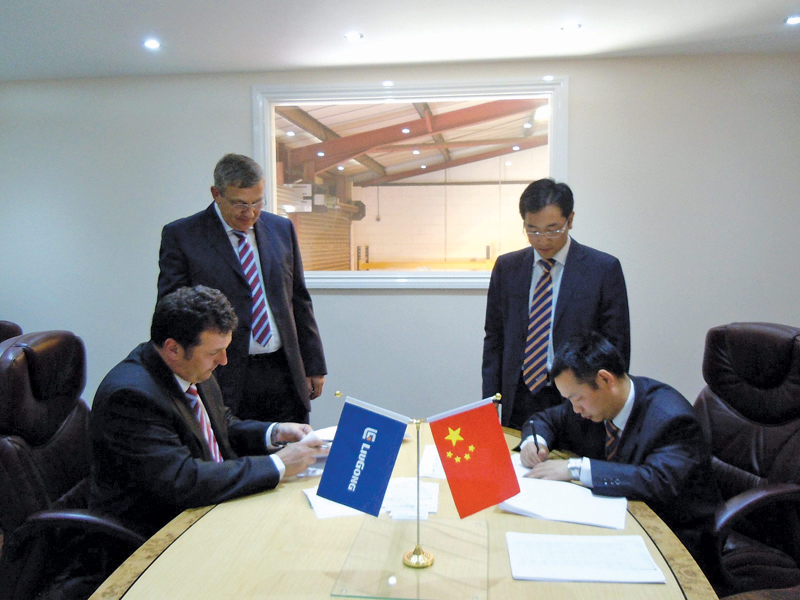 left-right: Grant McGregor, CPMS director and shareholder; Brian Prescott; Linjun Wang, sales manager LiuGong Machinery Europe; and Xiao Yuanxiang at the signing of the official dealership agreement between LiuGong and CPMS LiuGong southern England sales deal