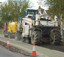 Spreading material to strengthen the tar bound road