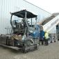 Dump truck emptying concrete into a Vogele paver 
