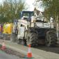 Spreading material to strengthen the tar bound road