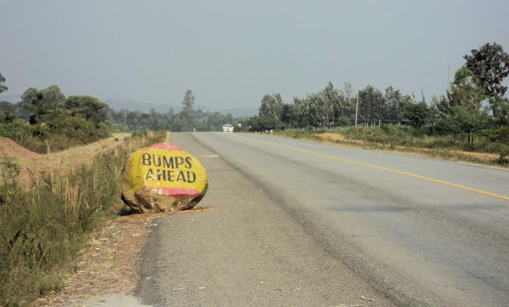 Rocky road warning signs by the roadside warn drivers of bumpy stretches ahead, but themselves post a possible hazard Rocky road warning sign