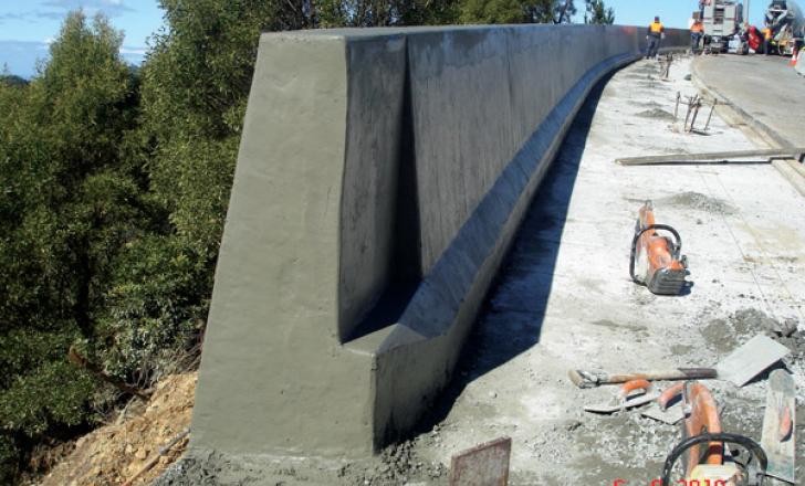Using the new power curbers 5700-c with the Max package has allowed an australian contractor to slipform a barrier and shoulder for a road project concrete barrier being erected